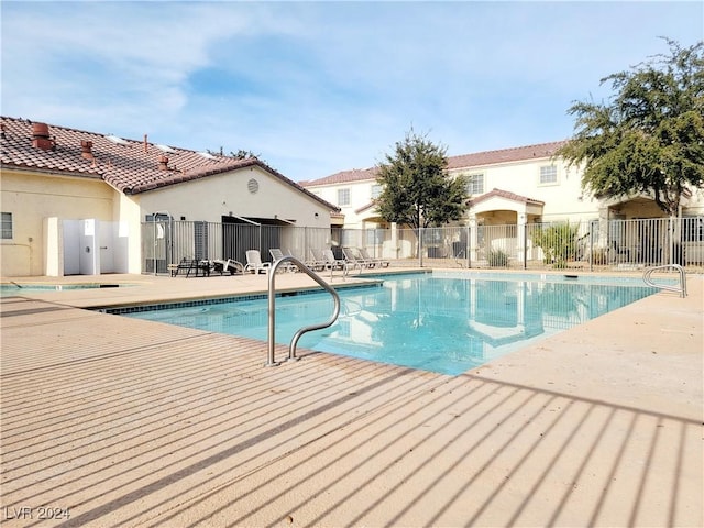 community pool featuring a patio area and fence