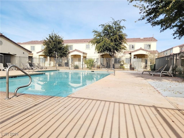 community pool featuring fence and a patio