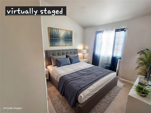 bedroom featuring vaulted ceiling and carpet flooring