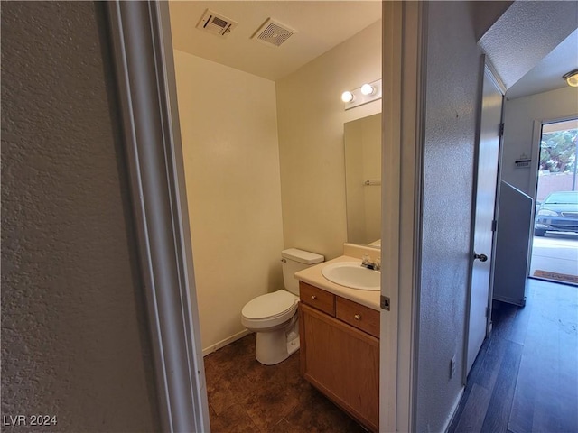 bathroom featuring toilet, visible vents, and vanity