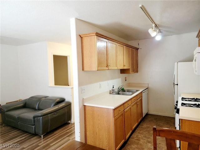 kitchen with light countertops, white appliances, a sink, and track lighting