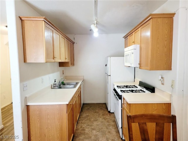 kitchen featuring light brown cabinets, white appliances, a sink, baseboards, and light countertops