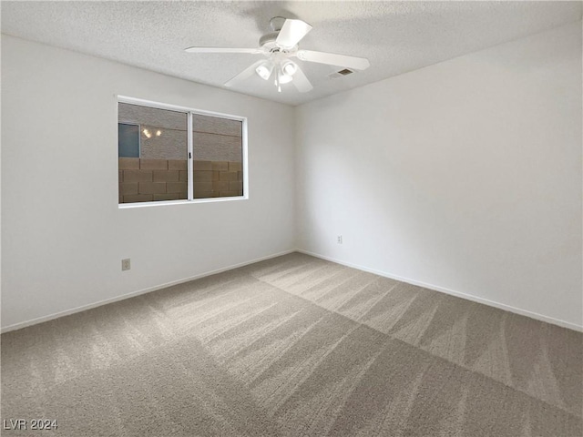 empty room with ceiling fan, carpet floors, and a textured ceiling