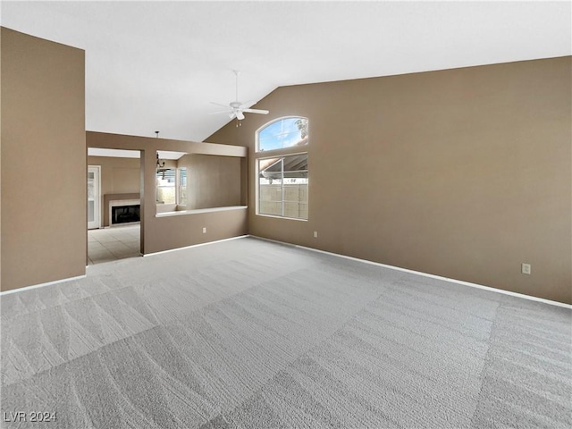 unfurnished living room featuring ceiling fan, light colored carpet, and lofted ceiling