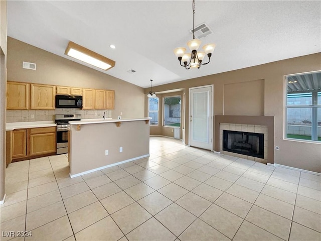 kitchen featuring backsplash, light tile patterned floors, stainless steel range oven, hanging light fixtures, and lofted ceiling