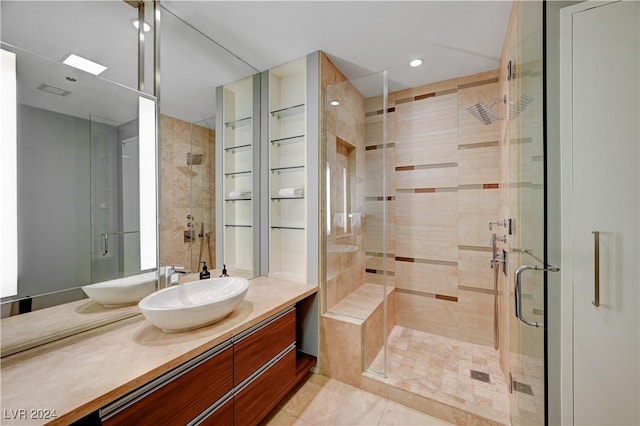 bathroom with tile patterned flooring, vanity, and walk in shower