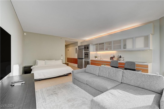 bedroom with light tile patterned flooring and stainless steel refrigerator