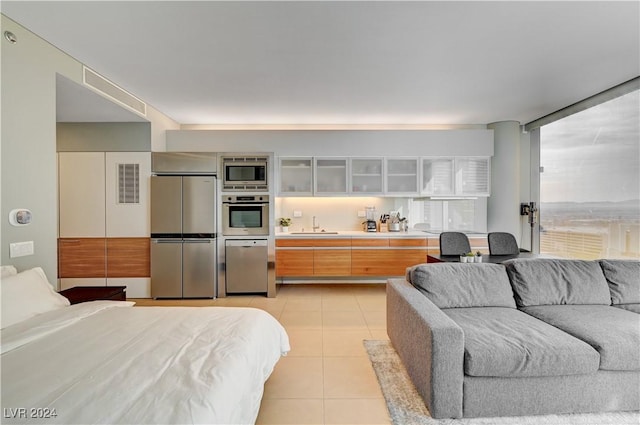 interior space featuring light tile patterned floors, sink, and appliances with stainless steel finishes