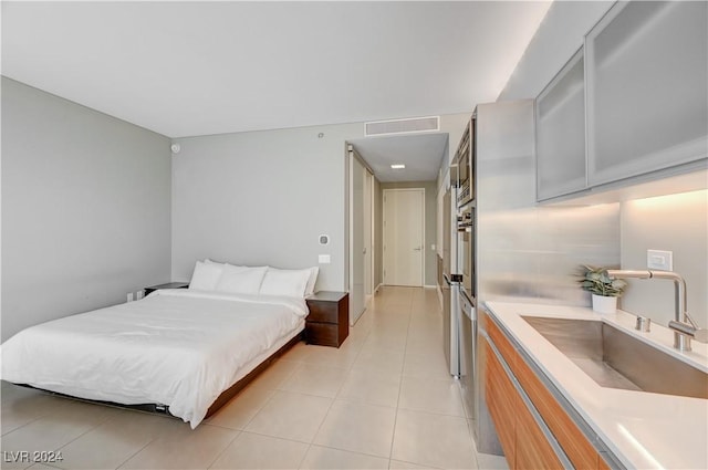 bedroom featuring light tile patterned floors and sink