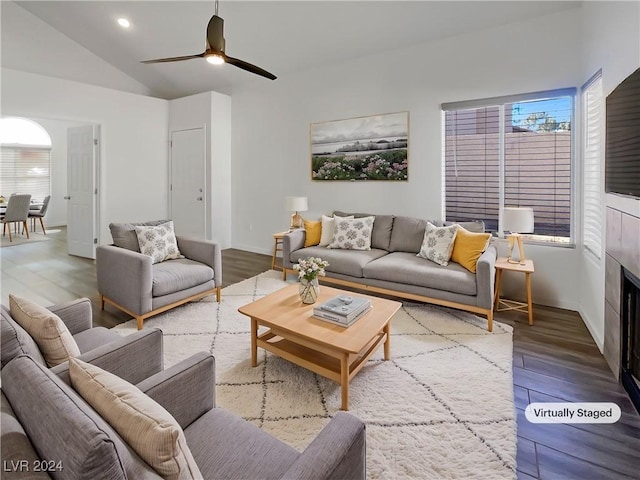 living room featuring hardwood / wood-style flooring, ceiling fan, and vaulted ceiling