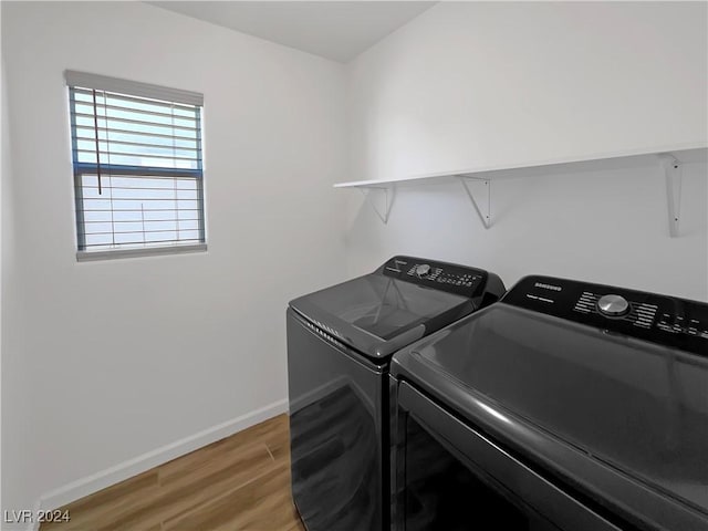 washroom with washer and clothes dryer and wood-type flooring