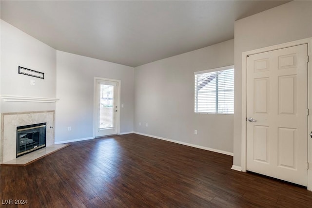 unfurnished living room featuring dark hardwood / wood-style floors and a premium fireplace