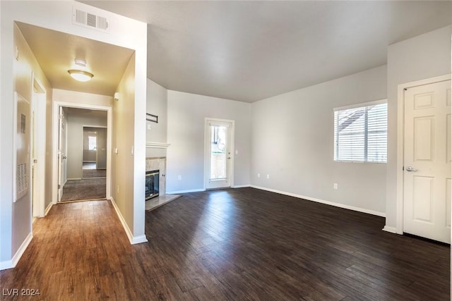 entryway featuring a fireplace, a wealth of natural light, and dark wood-type flooring