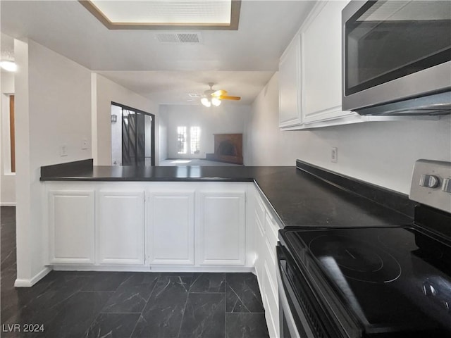 kitchen featuring white cabinets, kitchen peninsula, black electric range oven, and ceiling fan