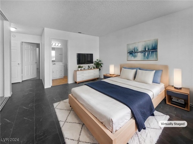 bedroom with ensuite bath and a textured ceiling