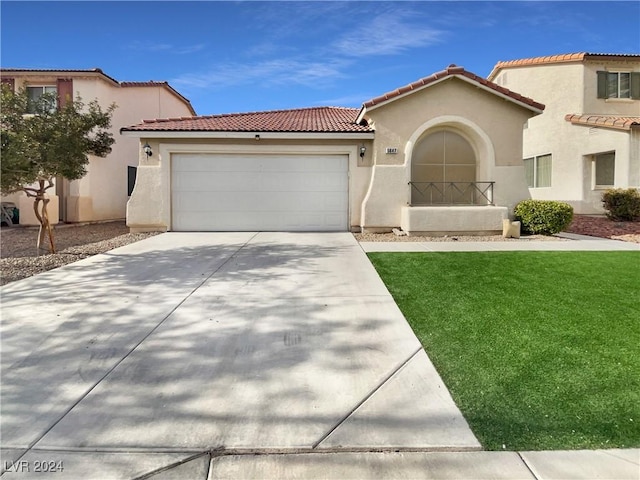 mediterranean / spanish-style house with a garage and a front lawn