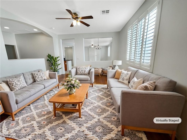 living room with hardwood / wood-style floors and ceiling fan with notable chandelier