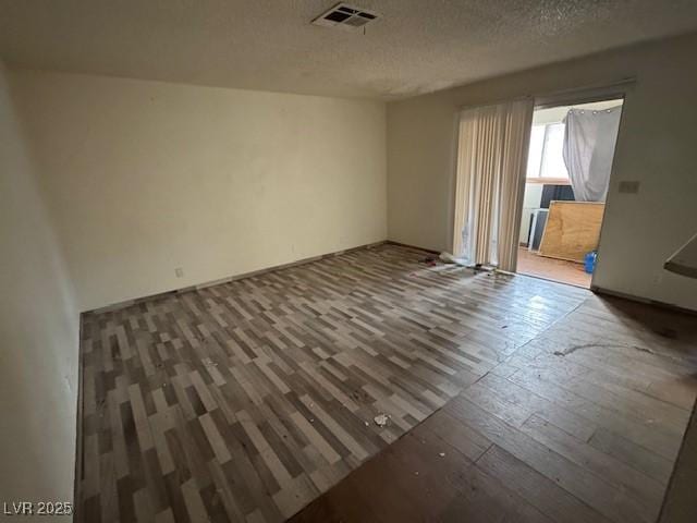 spare room with hardwood / wood-style floors and a textured ceiling