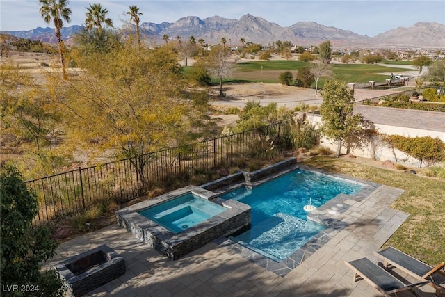 view of pool with an in ground hot tub, a mountain view, and a patio area