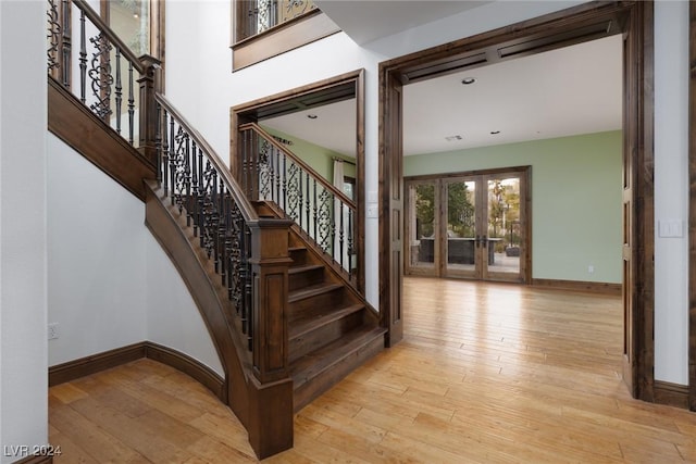 staircase with french doors and hardwood / wood-style floors