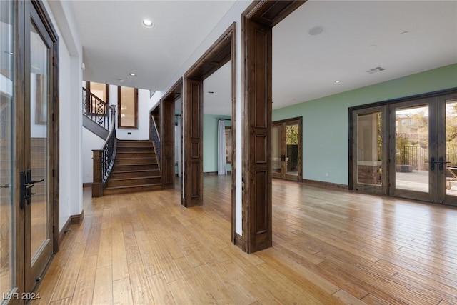 hallway with light wood-type flooring and french doors