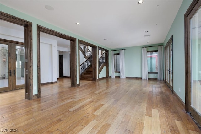 unfurnished living room with french doors and light hardwood / wood-style floors