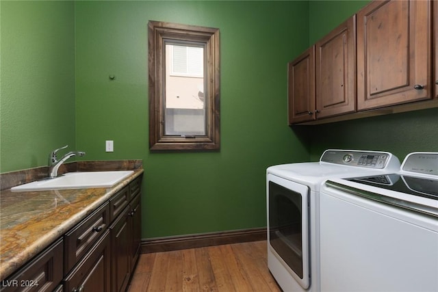 washroom with separate washer and dryer, sink, cabinets, and light wood-type flooring