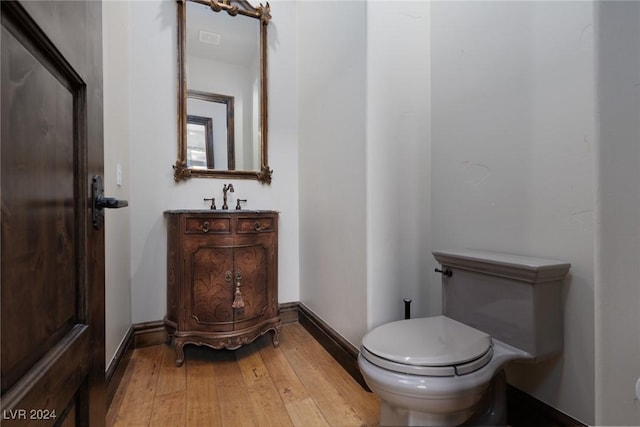 bathroom featuring hardwood / wood-style floors, vanity, and toilet