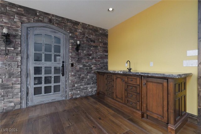 bar featuring dark hardwood / wood-style flooring and sink