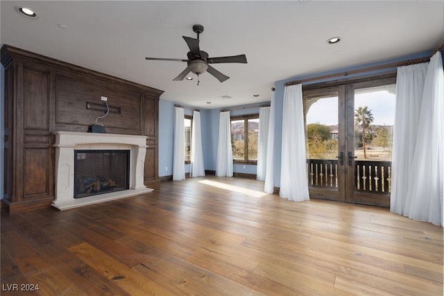 unfurnished living room featuring ceiling fan, a high end fireplace, and light hardwood / wood-style flooring