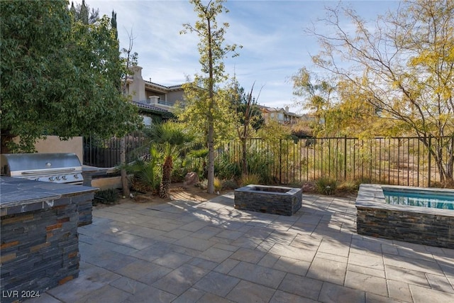 view of patio with a fire pit, an outdoor kitchen, and area for grilling