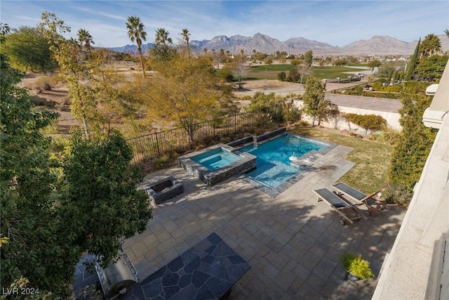 view of swimming pool featuring a mountain view, an in ground hot tub, and a patio