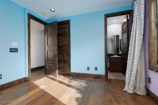 bedroom featuring wood-type flooring, sink, and connected bathroom