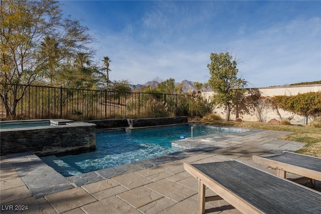 view of pool with an in ground hot tub, pool water feature, and a patio area