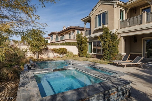 view of pool with an in ground hot tub and a patio