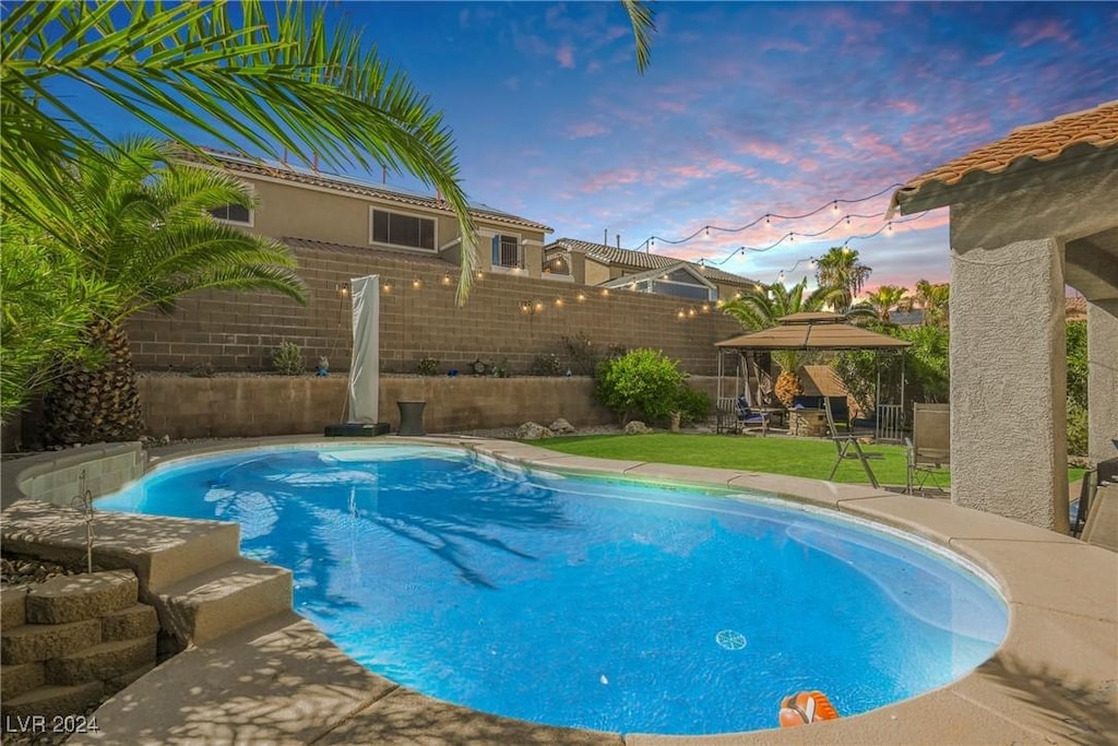 pool at dusk with a gazebo