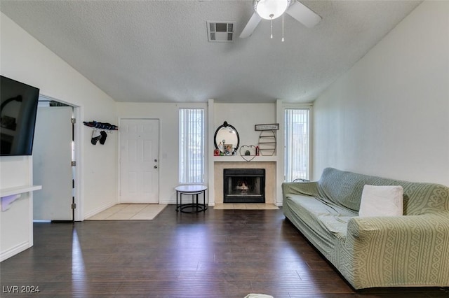 living room featuring ceiling fan, lofted ceiling, hardwood / wood-style floors, and a textured ceiling