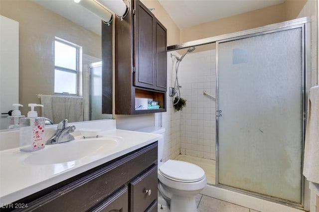 bathroom featuring walk in shower, vanity, toilet, and tile patterned flooring