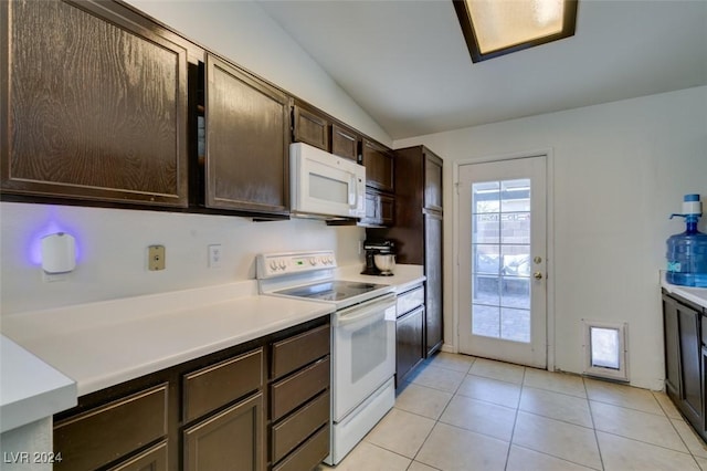 kitchen with light tile patterned floors, white appliances, vaulted ceiling, and dark brown cabinets