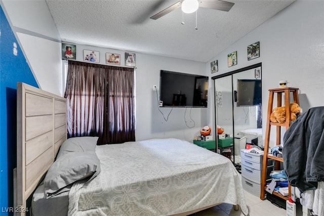 bedroom featuring ceiling fan, a closet, and a textured ceiling