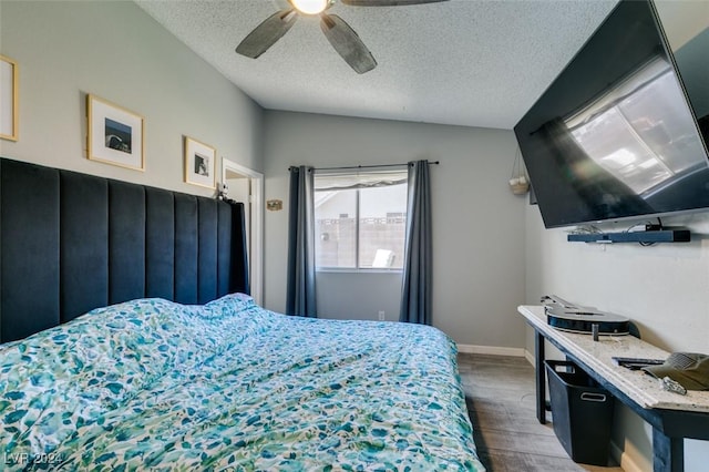 bedroom featuring ceiling fan, wood-type flooring, a textured ceiling, and vaulted ceiling