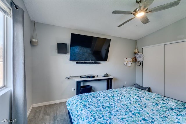 bedroom featuring lofted ceiling, wood-type flooring, a closet, and ceiling fan