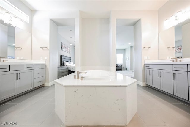 bathroom with tile patterned flooring, vanity, and a bath