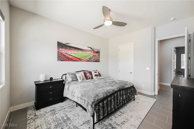 tiled bedroom with multiple windows and ceiling fan