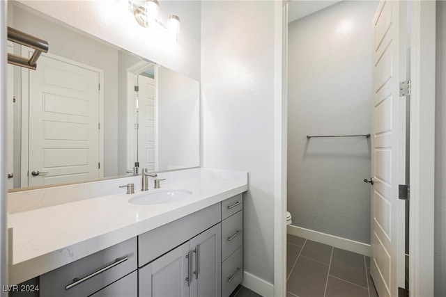 bathroom featuring tile patterned flooring, vanity, and toilet