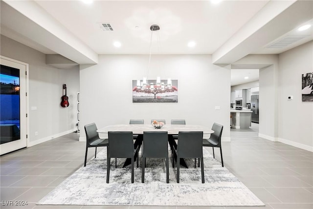 dining area featuring tile patterned flooring and an inviting chandelier