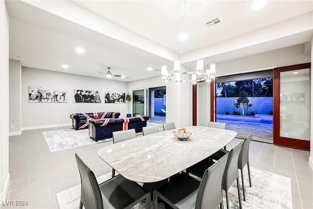 tiled dining area with ceiling fan with notable chandelier