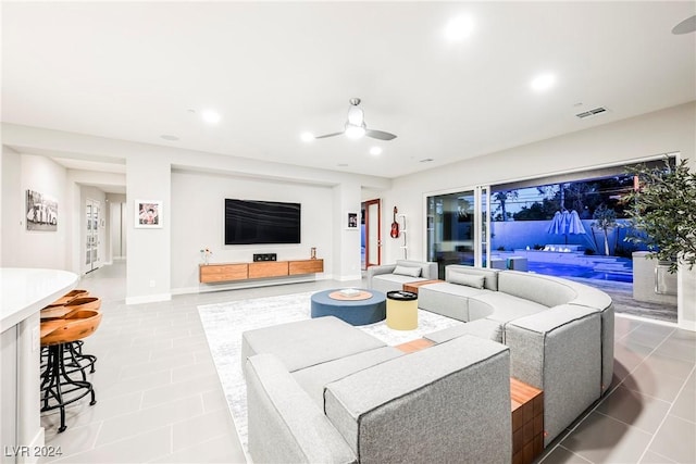 living room featuring tile patterned floors and ceiling fan