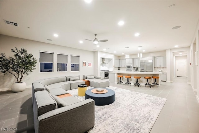 living room with light tile patterned floors and ceiling fan