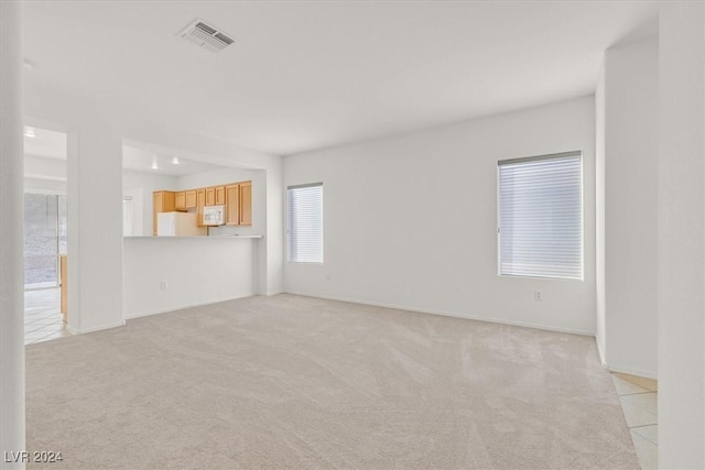 unfurnished living room with light colored carpet